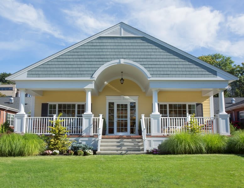 A charming single-story house with a welcoming porch and well-maintained front lawn.