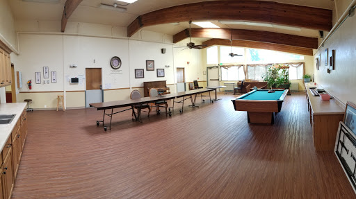 A spacious interior featuring a pool table and multiple tables for gatherings.
