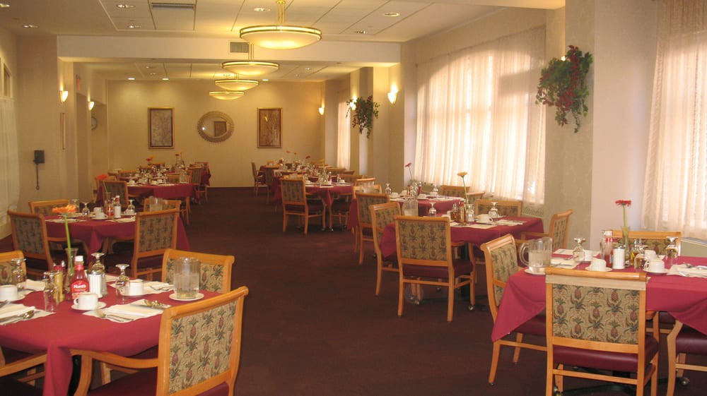 A spacious and well-lit dining room with elegantly arranged tables and chairs.