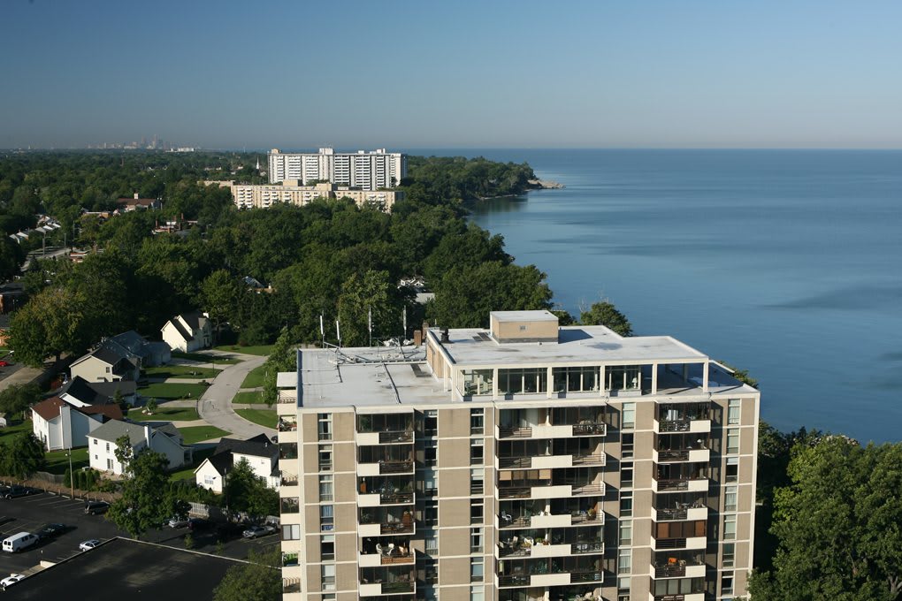 Aerial view of a residential area by the lake with apartment buildings and lush greenery.
