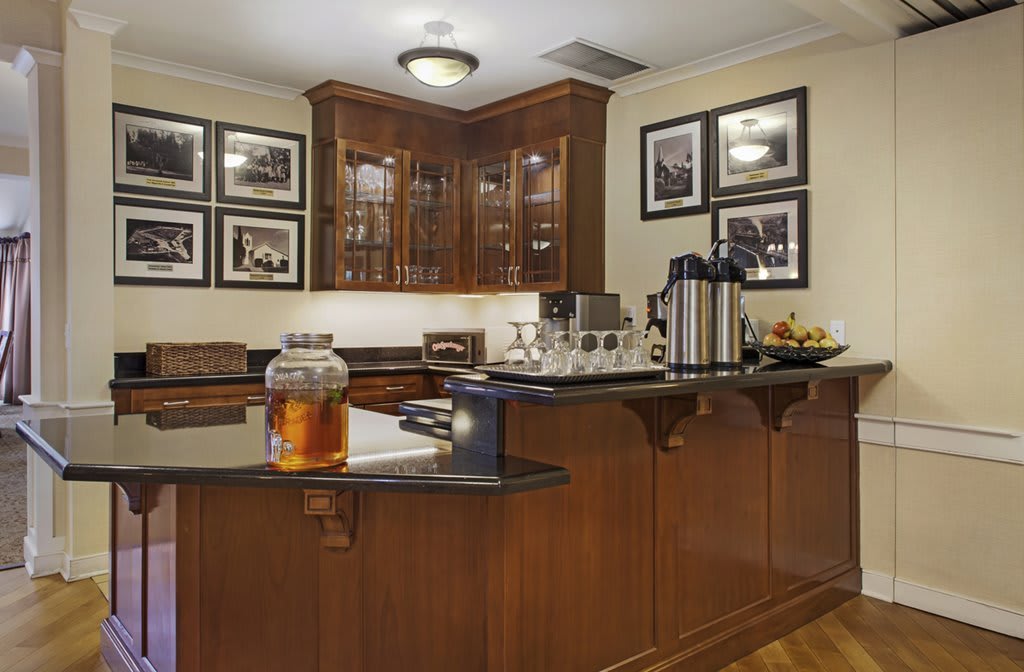 A well-organized kitchen area with wooden cabinets and a coffee station.