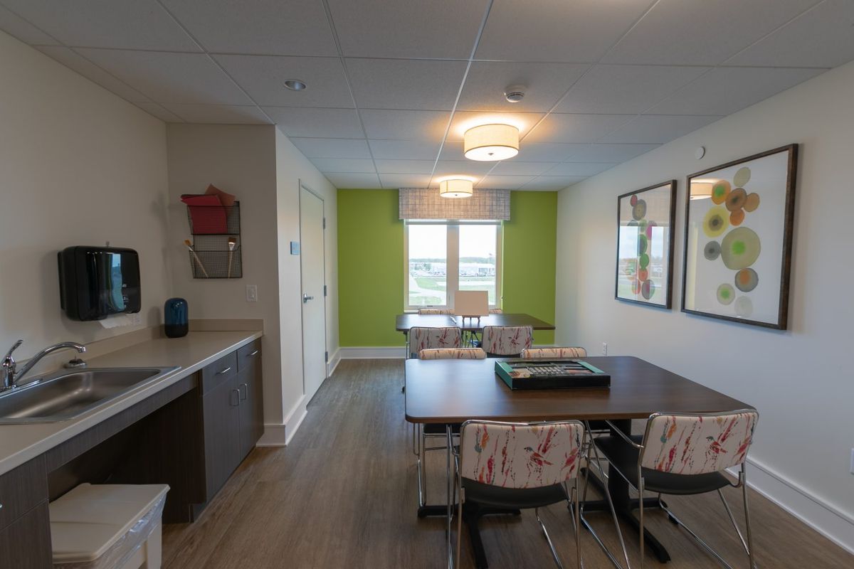 A modern kitchen and dining area with a vibrant green accent wall.