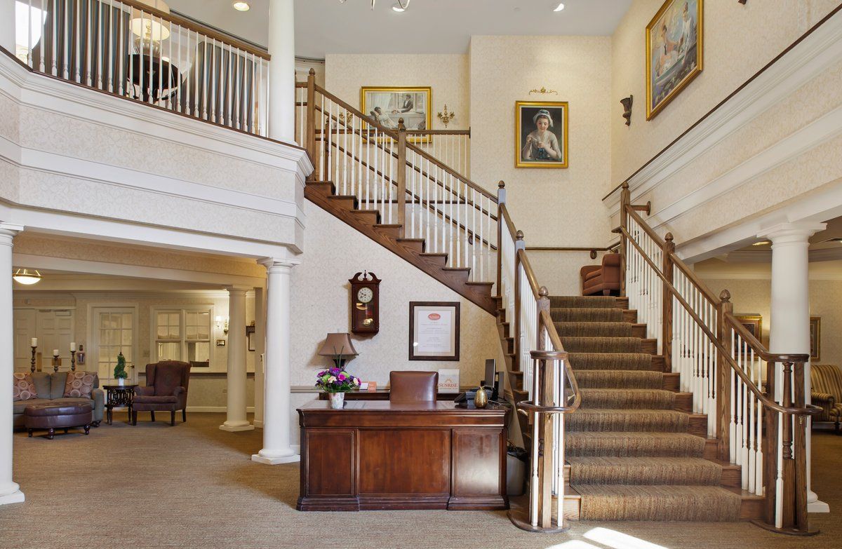 Elegant lobby featuring a grand staircase and a wooden desk.