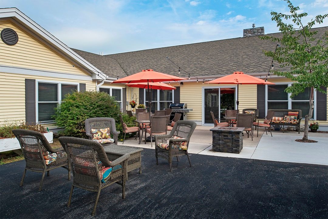 A cozy outdoor patio area with wicker chairs and bright orange umbrellas.