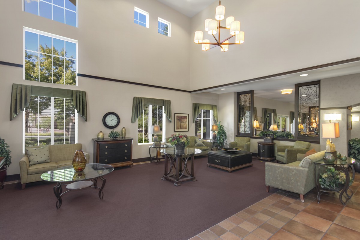 Spacious living room with high ceilings, elegant decor, and a chandelier.