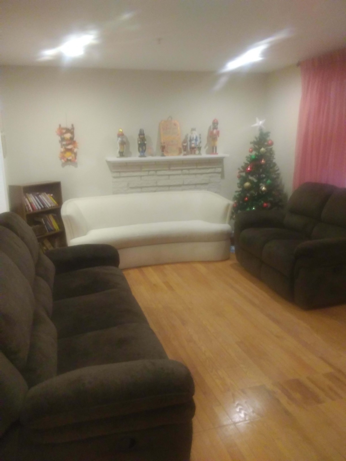 A cozy living room with sofas and a decorated Christmas tree.