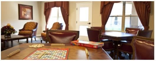 A cozy room with a Scrabble board game set on a table surrounded by chairs.