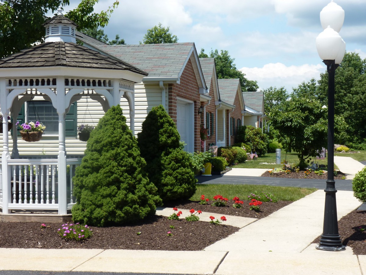 A suburban neighborhood with neatly landscaped gardens and houses lining the street.