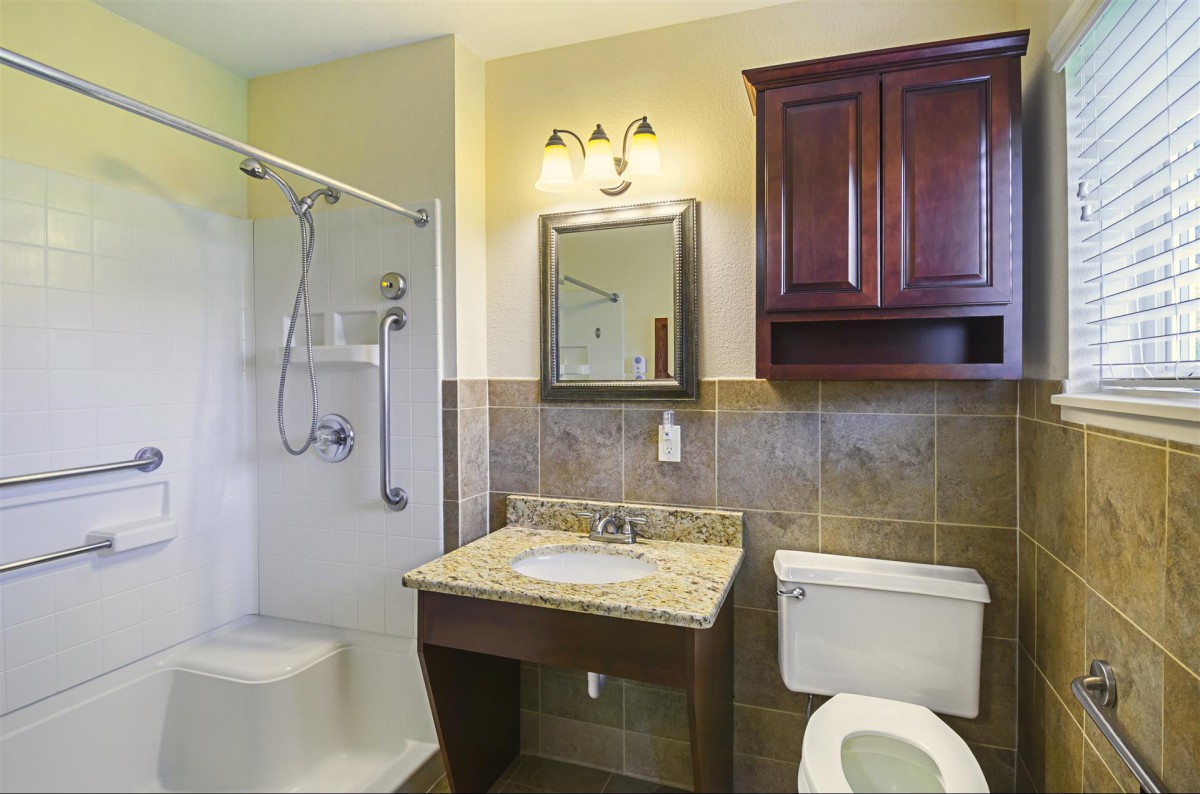 A clean and modern bathroom with a shower, sink, and toilet.