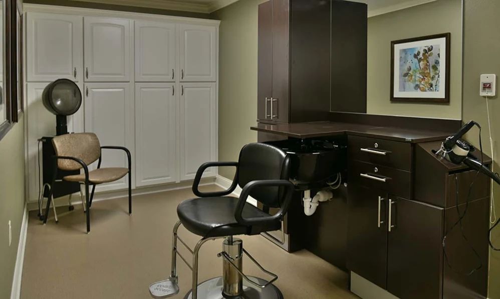 A modern salon interior featuring a barber chair and sink with cabinetry in the background.