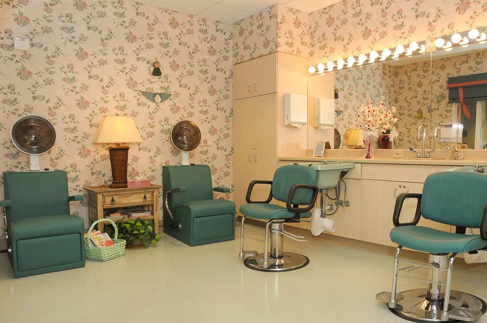 A vintage hair salon with floral wallpaper and retro styling chairs.