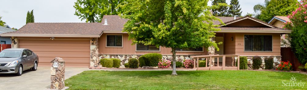 A suburban house with a well-maintained lawn and landscaping.