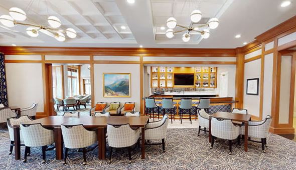 A contemporary dining and bar area with stylish furniture, modern lighting, and decorative artwork.