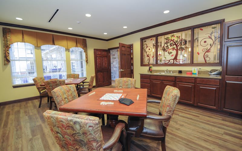 A cozy dining area with a wooden table, upholstered chairs, and decorative artwork on the walls.