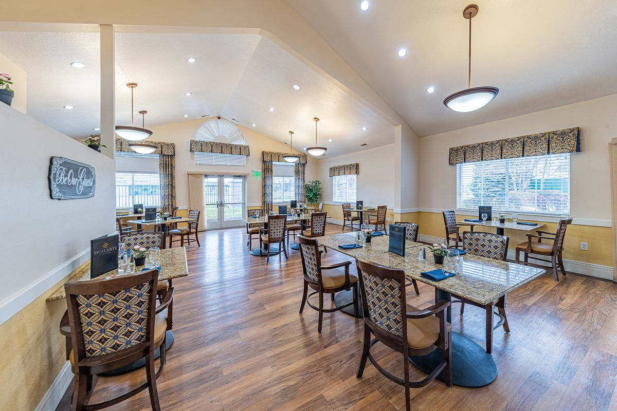 A spacious dining area with elegant tables and chairs, featuring wooden flooring and modern lighting.