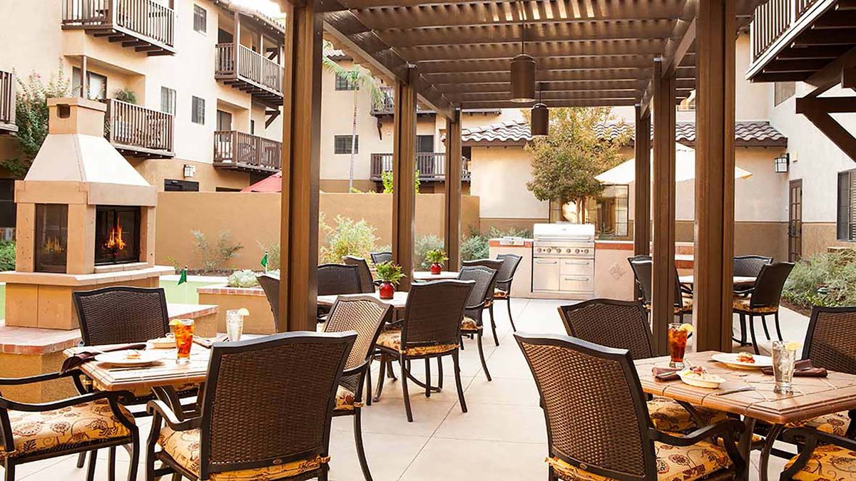 Outdoor patio seating area with a pergola and tables.