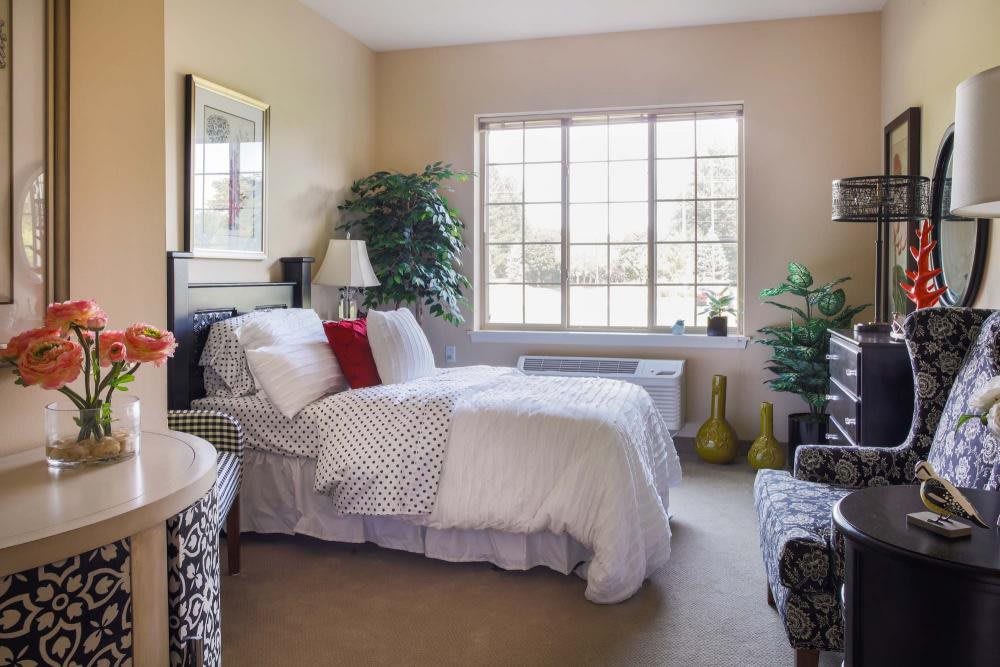 A cozy bedroom with stylish decor and natural lighting.