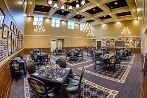 An elegant dining area with well-arranged tables and chandeliers.