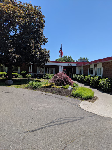 A well-maintained building with lush landscaping and a flag flying in the front.