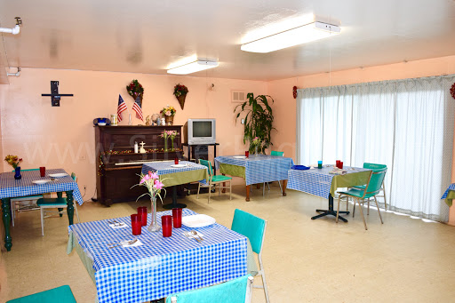 A cozy dining area featuring blue checkered tablecloths and a piano, creating a welcoming atmosphere.