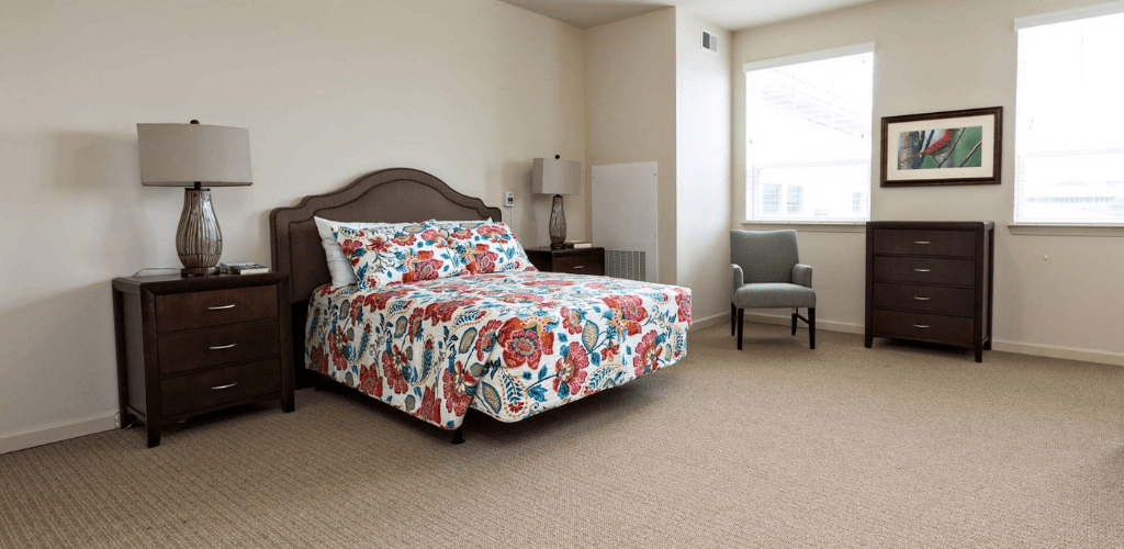 A cozy bedroom with floral bedding and neutral decor.