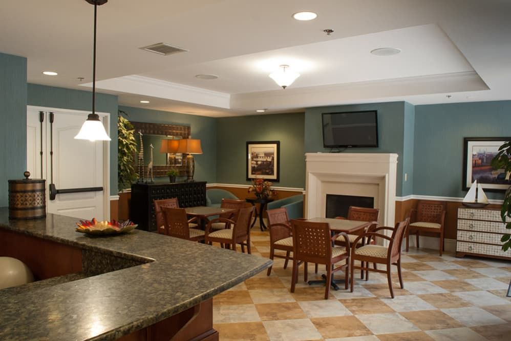 A cozy indoor seating area with tables, chairs, and a fireplace.
