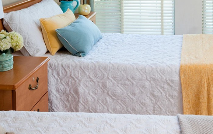 A cozy bedroom setup with neatly made beds adorned with decorative pillows.
