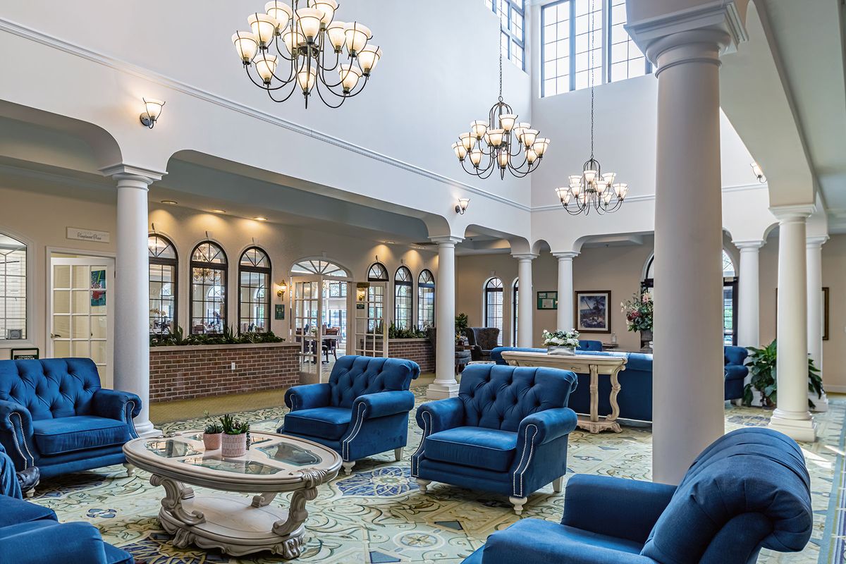 A luxurious lobby with blue sofas and elegant chandeliers.