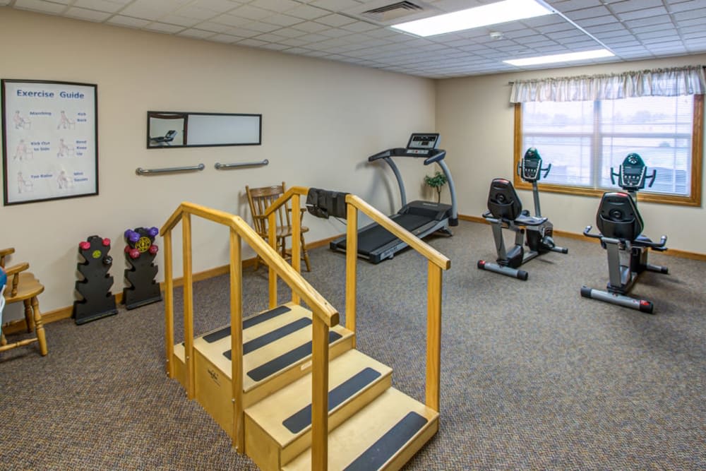 A fitness room equipped with exercise machines and rehabilitation stairs.