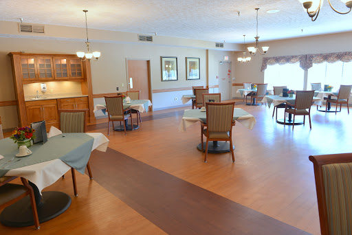 A spacious and well-lit dining area featuring tables and chairs designed for communal gatherings.