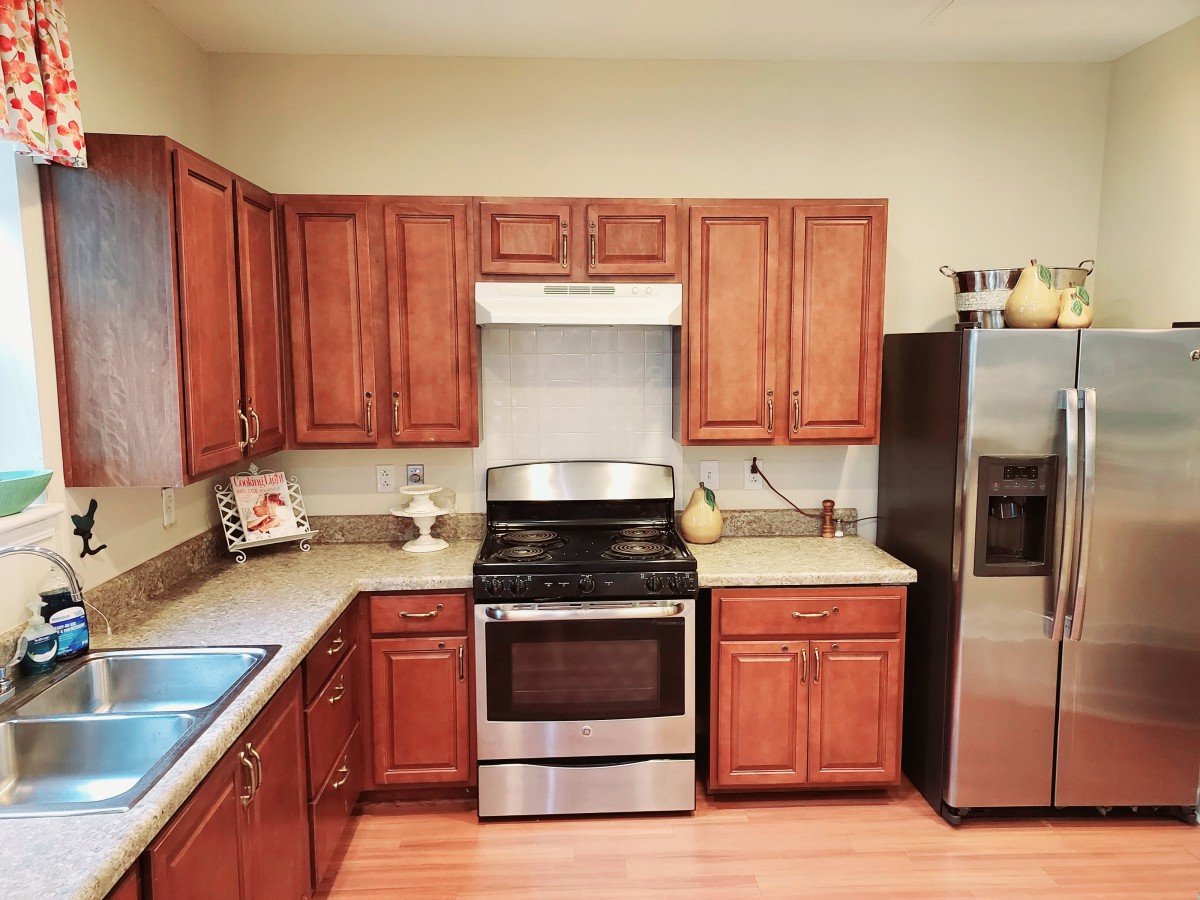 A modern kitchen with wooden cabinets and stainless steel appliances.