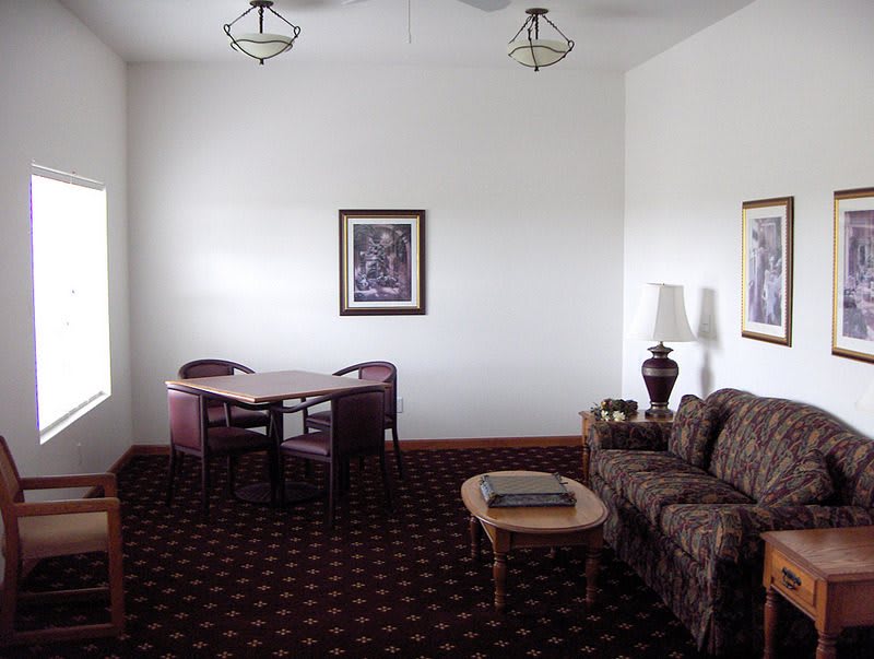 A cozy living room with a sofa, coffee table, and dining area.