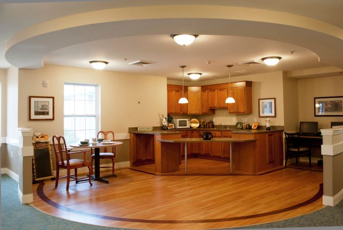 An open kitchen with wooden cabinetry and a small dining area.