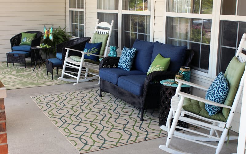 A cozy porch with rocking chairs and blue cushioned seating.