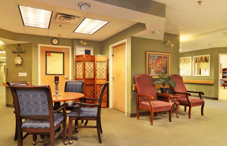 A cozy waiting room with comfortable chairs and a table, complemented by warm decor.
