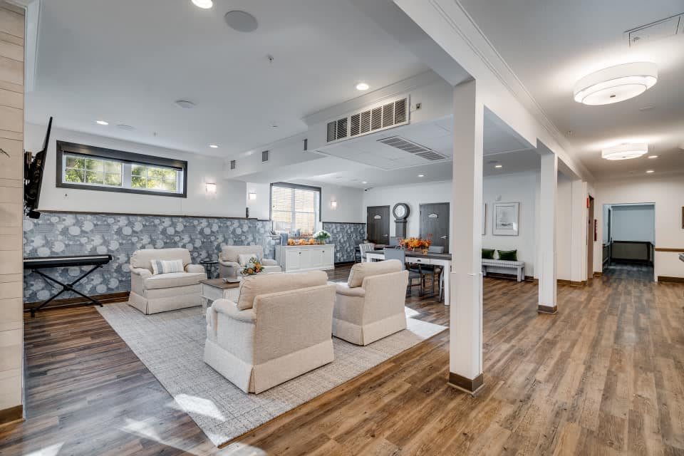 A modern living room with comfortable seating, natural light, and hardwood flooring.