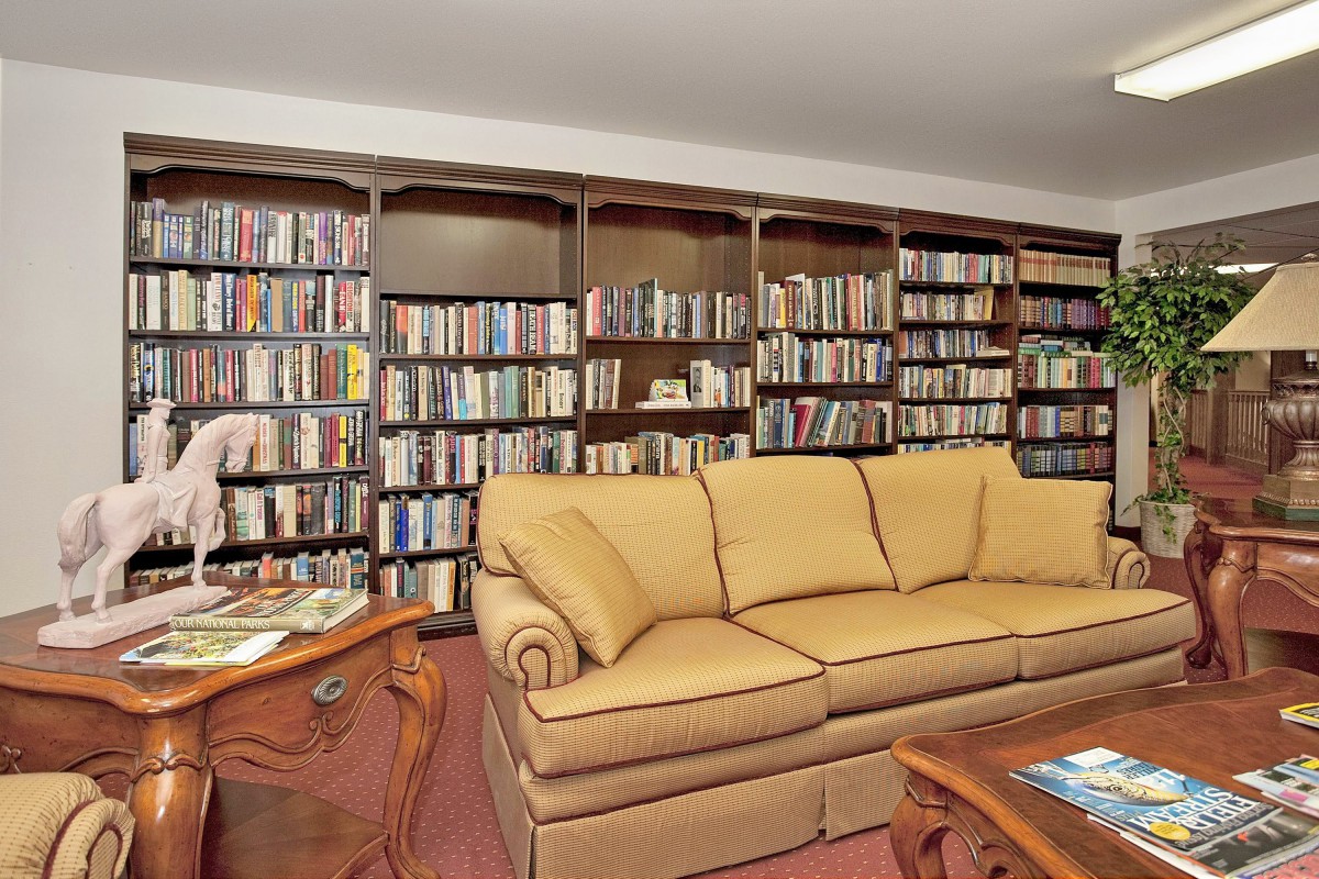 A cozy library with wooden bookshelves and a comfortable sofa.