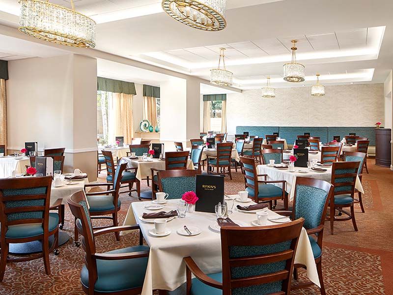 An elegant restaurant dining area with neatly arranged tables and chairs, ready for service.