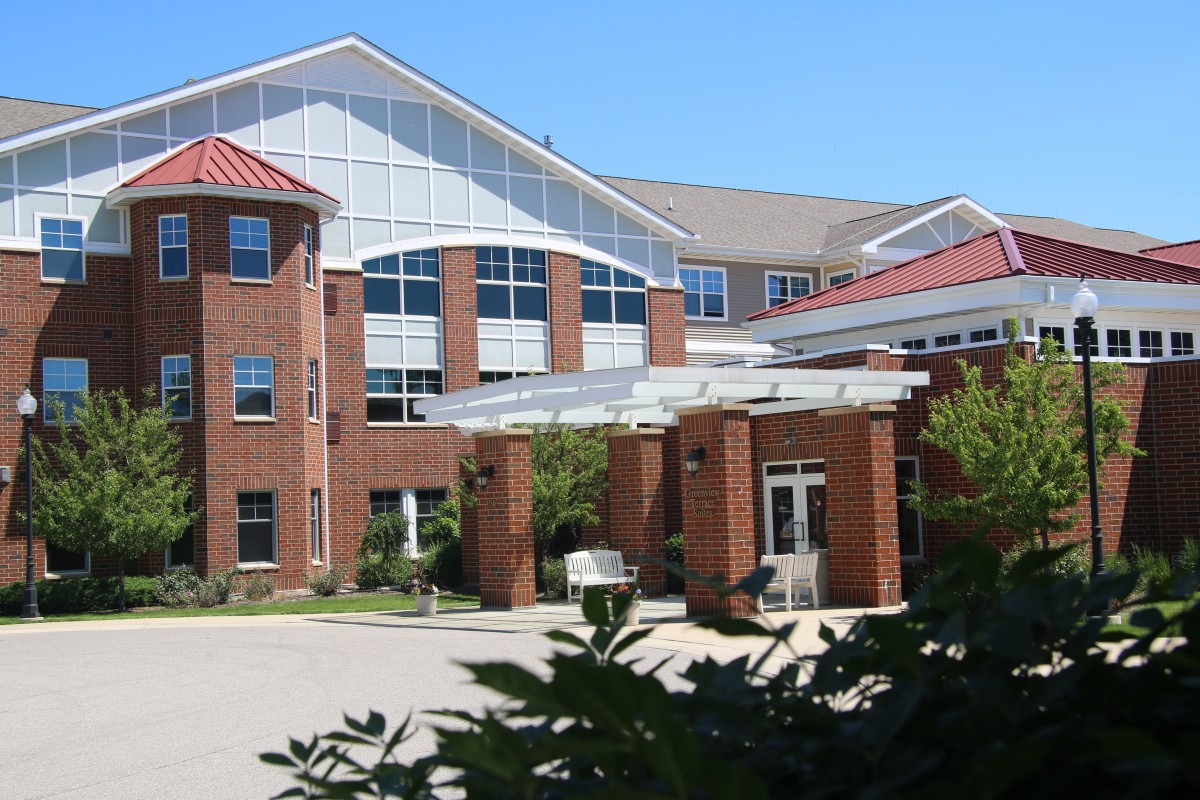 A modern hospital building with a prominent entrance and red brick facade.