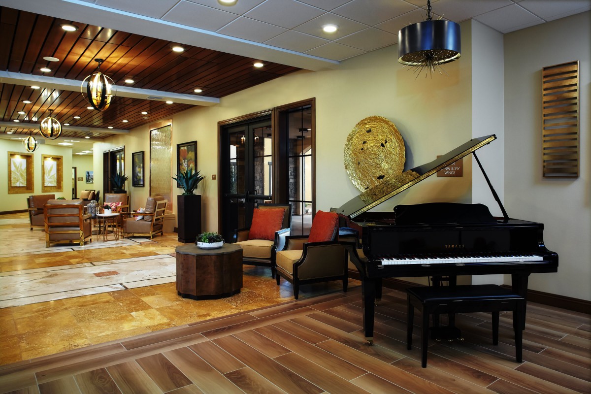A modern living room featuring a grand piano and stylish furnishings.