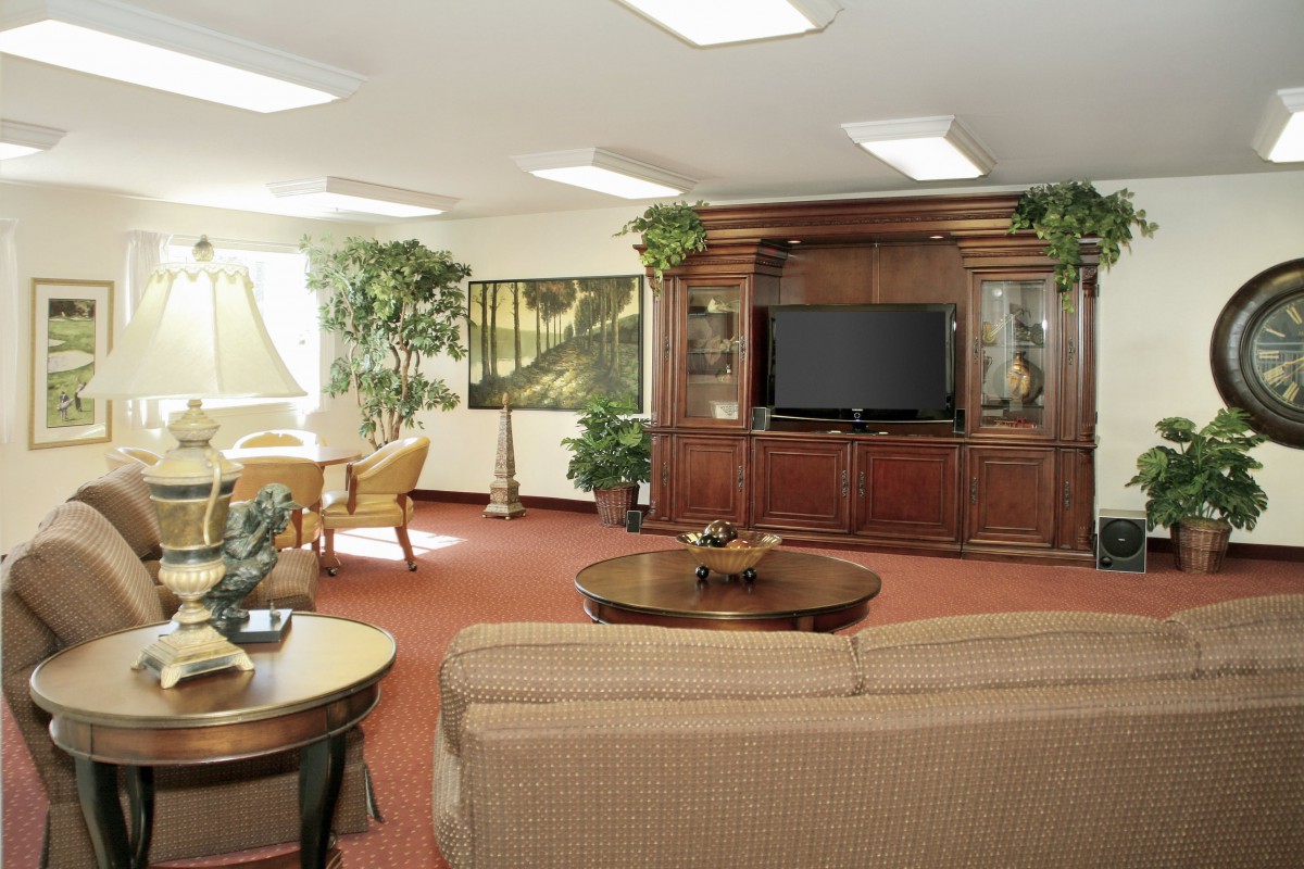 A cozy living room with a large wooden entertainment center and comfortable seating.