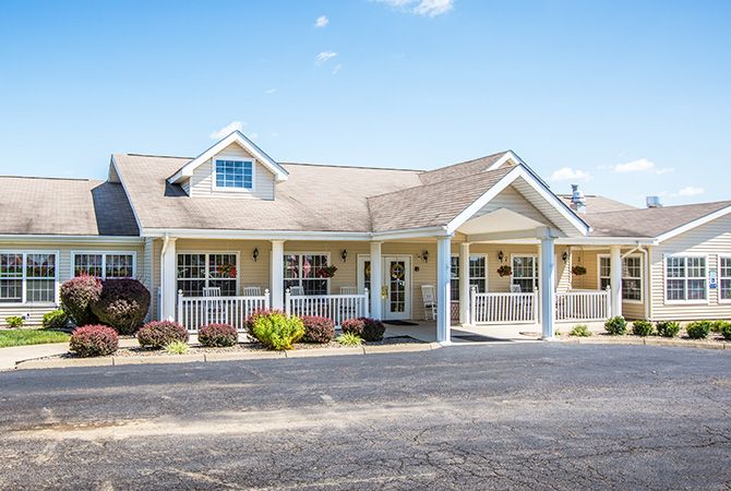 A charming single-story house with a front porch under a clear blue sky.