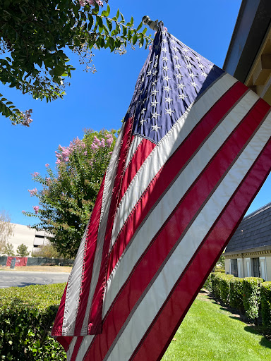 The American flag proudly displays its colors against a clear blue sky.