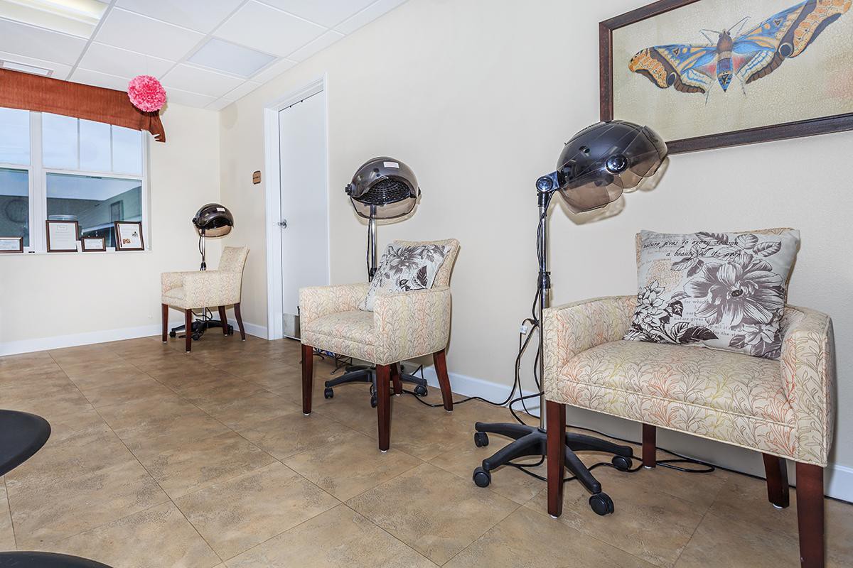 A cozy salon waiting area with chairs and hair dryers.