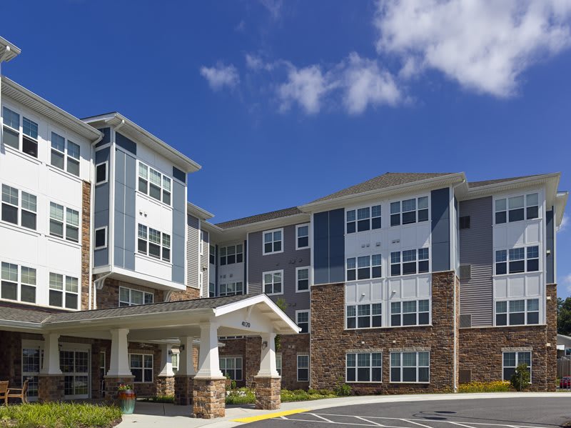 Modern residential apartment building under a clear blue sky.