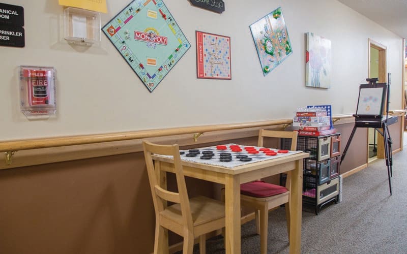 A cozy game room with Monopoly-themed decor and a table set up for playing games.