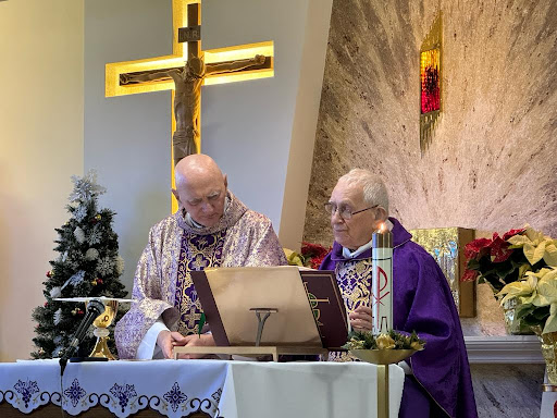 Two clergy members participating in a religious service at a church.