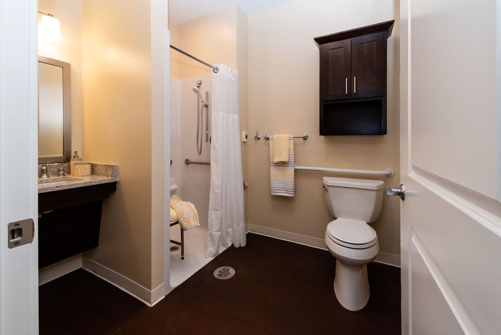 A modern bathroom with a shower, toilet, and sink.