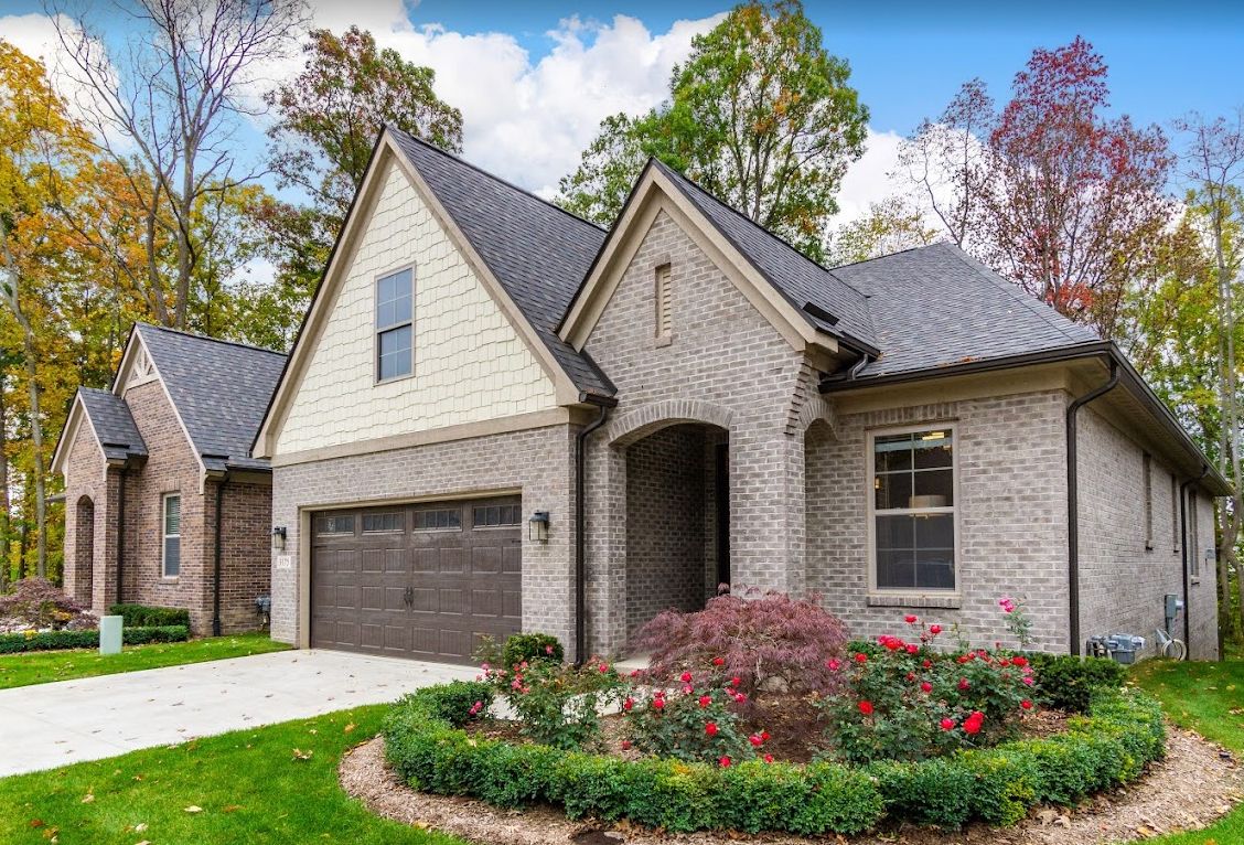 A modern brick house with a landscaped garden and attached garage.