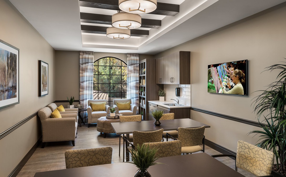 A modern and stylish living room featuring comfortable sofas, elegant lighting fixtures, and a dining area.